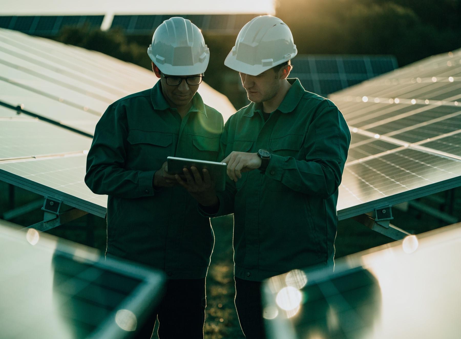 Profesionales revisando información técnica junto a paneles solares